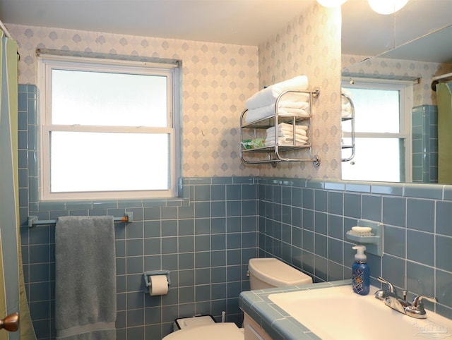 bathroom with vanity, tile walls, and toilet