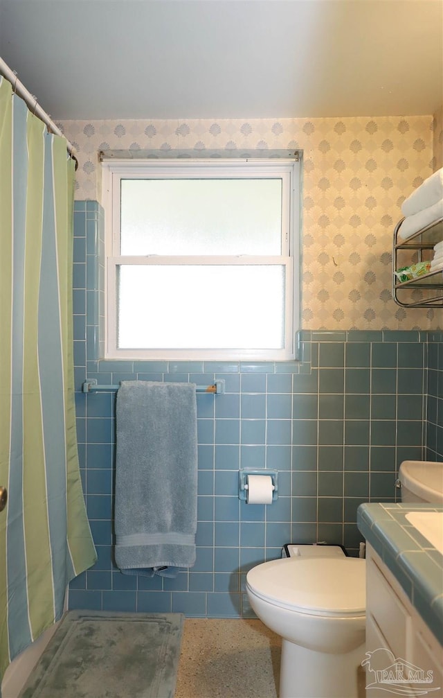 bathroom with vanity, a wealth of natural light, tile walls, and toilet