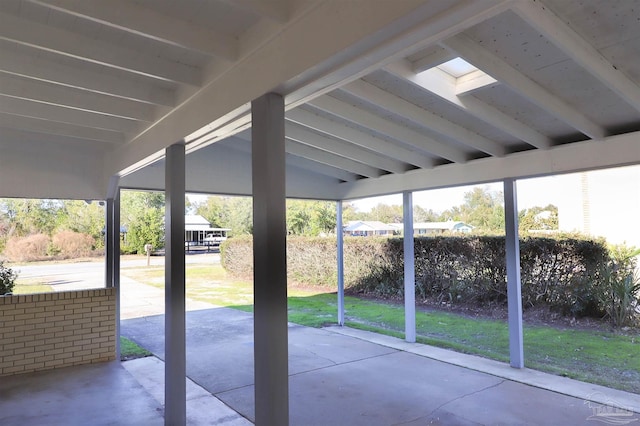 unfurnished sunroom featuring lofted ceiling with beams