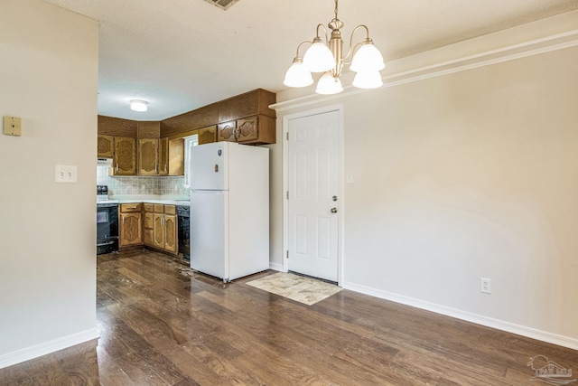 kitchen featuring black range with electric cooktop, tasteful backsplash, hanging light fixtures, white refrigerator, and dark hardwood / wood-style floors