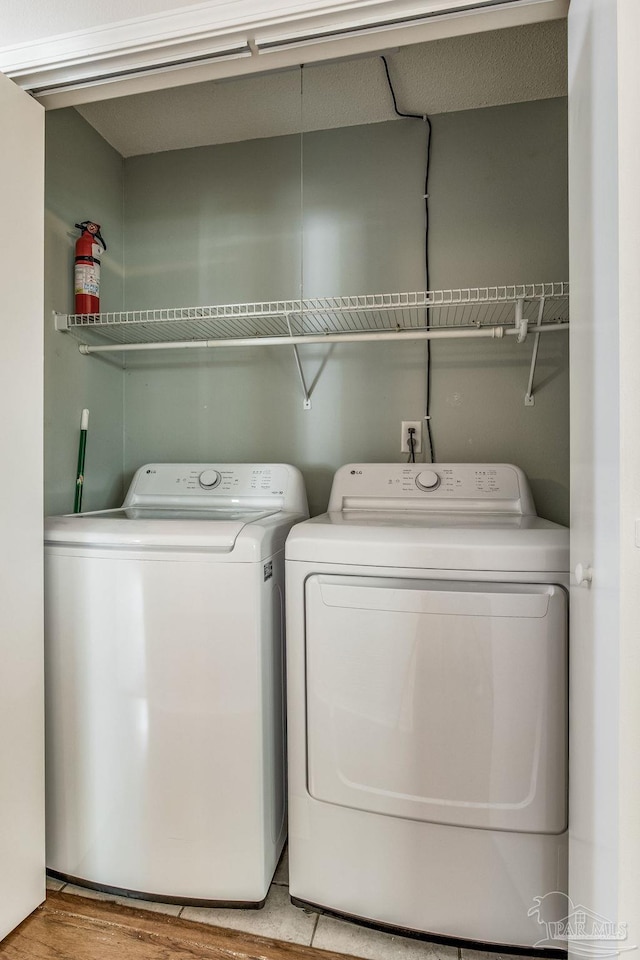 laundry room featuring independent washer and dryer and light hardwood / wood-style floors