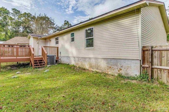 back of house with a wooden deck, a lawn, and central air condition unit