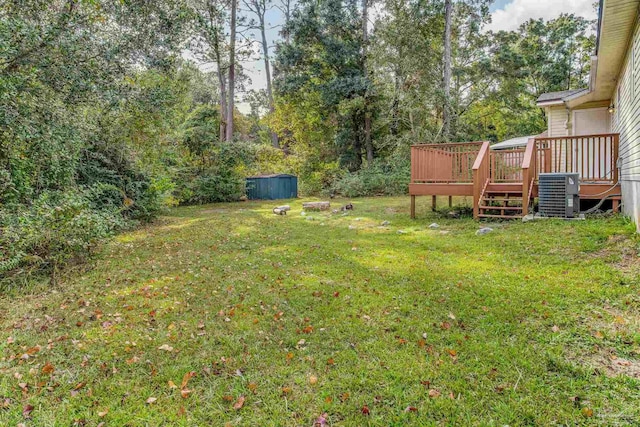 view of yard featuring a deck and central AC unit