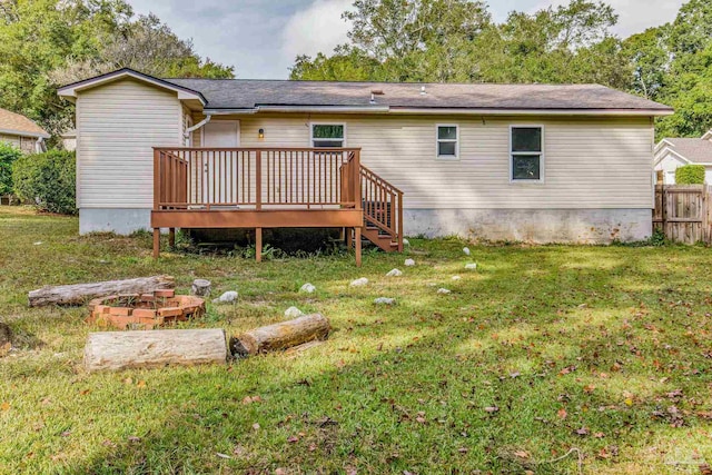 rear view of house with a deck and a lawn