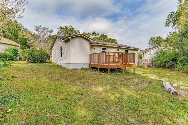 back of house with a wooden deck and a lawn