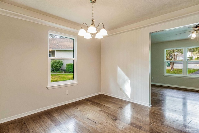 empty room with wood-type flooring, a textured ceiling, ceiling fan with notable chandelier, and ornamental molding