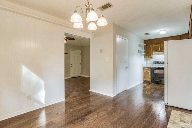 kitchen featuring hanging light fixtures, dark hardwood / wood-style flooring, white refrigerator, a textured ceiling, and electric range oven