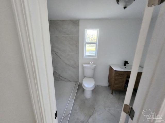 bathroom featuring toilet, a shower stall, and vanity