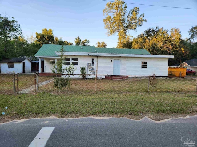 ranch-style house featuring entry steps, metal roof, a fenced front yard, a gate, and a front yard