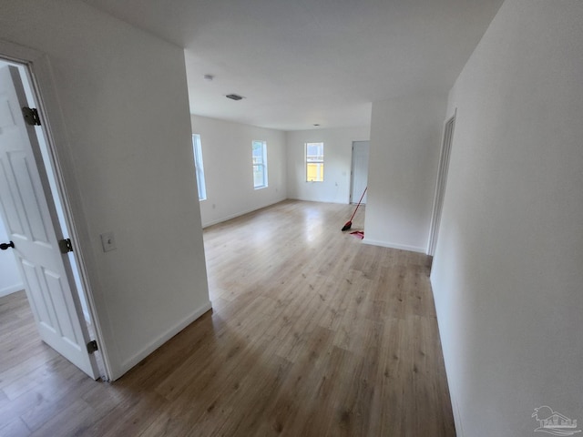 unfurnished living room with visible vents, baseboards, and wood finished floors