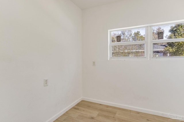 spare room with light wood-style floors and baseboards