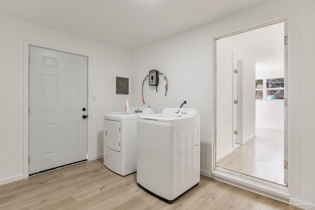 laundry room featuring light wood finished floors, laundry area, separate washer and dryer, and baseboards