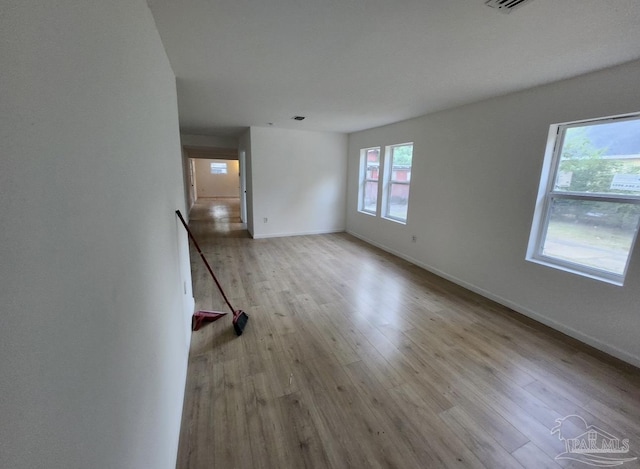 unfurnished living room featuring wood finished floors, visible vents, and baseboards