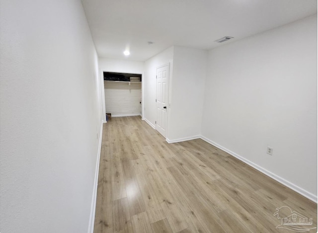 spare room featuring baseboards, visible vents, and light wood-style floors