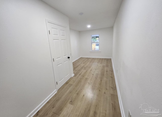 spare room featuring baseboards and light wood finished floors