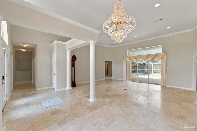 empty room featuring a notable chandelier, crown molding, and decorative columns