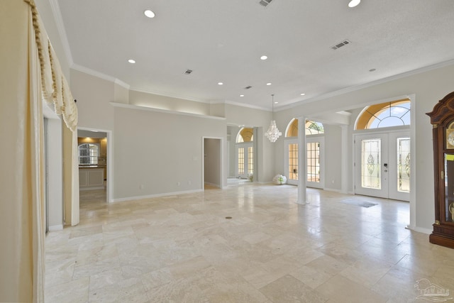 unfurnished living room featuring crown molding, a towering ceiling, and french doors