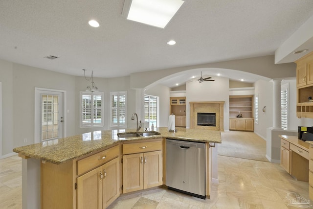 kitchen featuring sink, light brown cabinets, stainless steel dishwasher, an island with sink, and ceiling fan