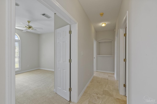 hallway featuring light colored carpet