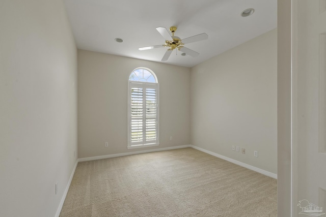 spare room with light colored carpet and ceiling fan