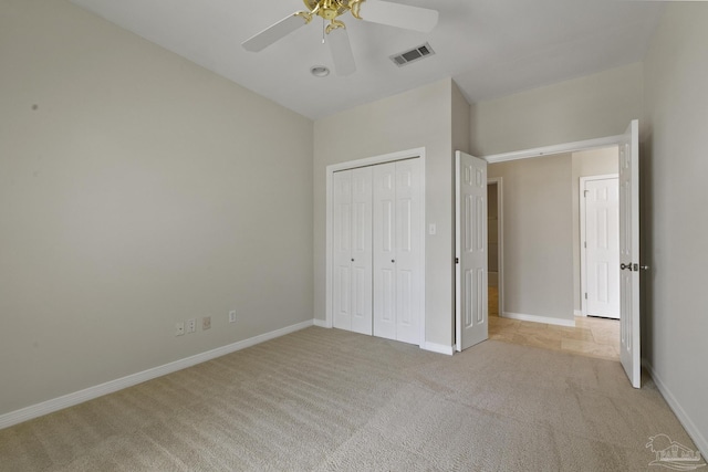 unfurnished bedroom with light colored carpet, a closet, and ceiling fan