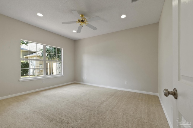 carpeted spare room featuring ceiling fan