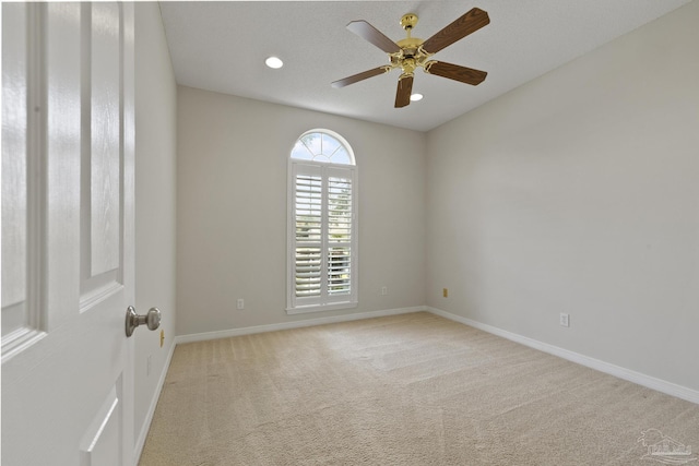 carpeted empty room featuring ceiling fan