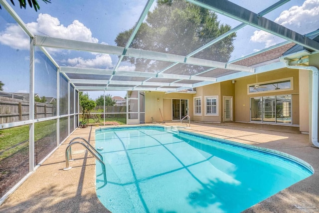 view of swimming pool featuring a patio and glass enclosure