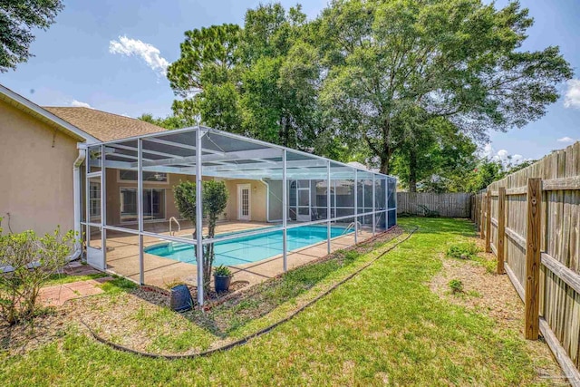 view of swimming pool featuring a patio, glass enclosure, and a lawn