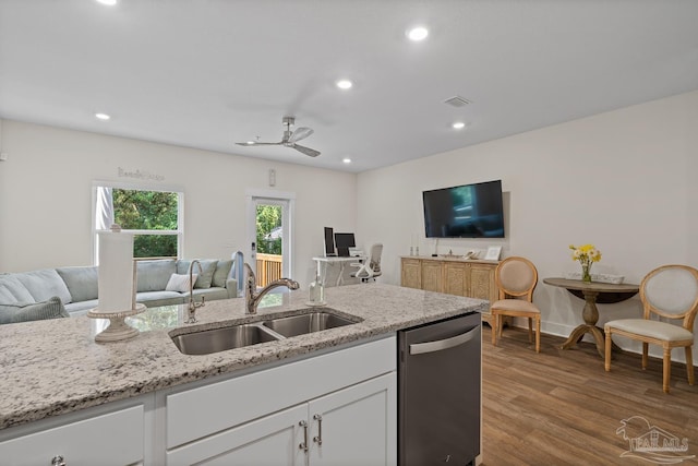 kitchen featuring visible vents, stainless steel dishwasher, open floor plan, white cabinets, and a sink