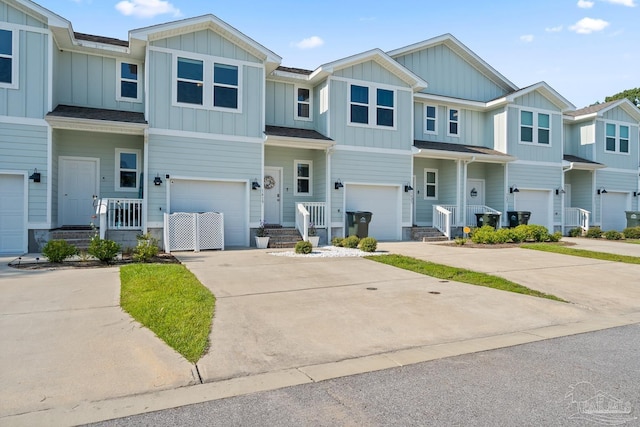 townhome / multi-family property with concrete driveway, board and batten siding, an attached garage, and a residential view