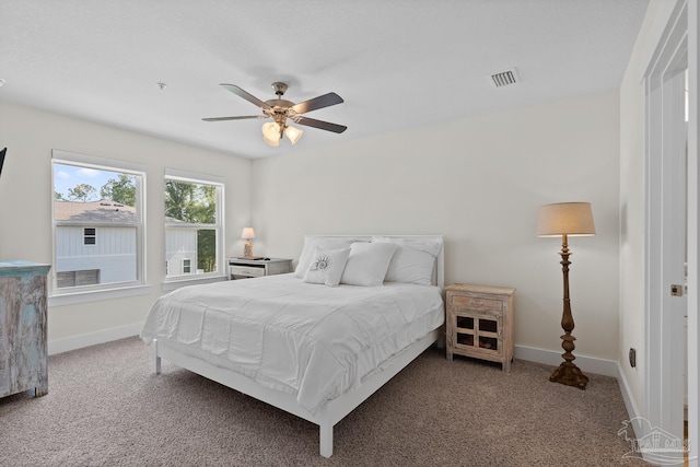 carpeted bedroom featuring baseboards, visible vents, and ceiling fan