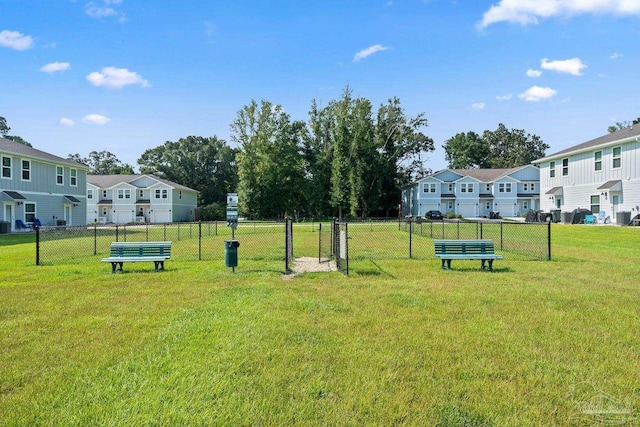 view of community with a residential view, a yard, and fence