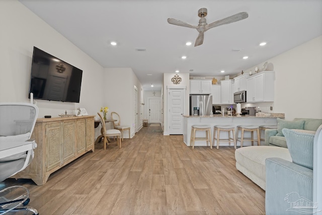 living room with a ceiling fan, recessed lighting, visible vents, and light wood-style flooring