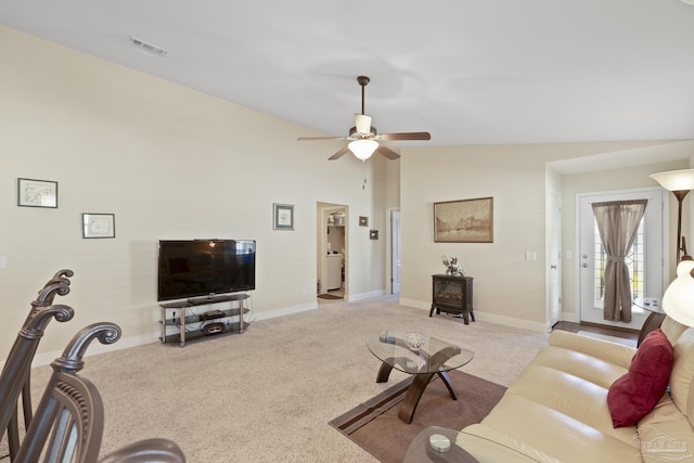 5183 Teresa Dr, Milton, FL 32583 - living room with carpet flooring, ceiling fan, vaulted ceiling, a wood stove, and baseboards
