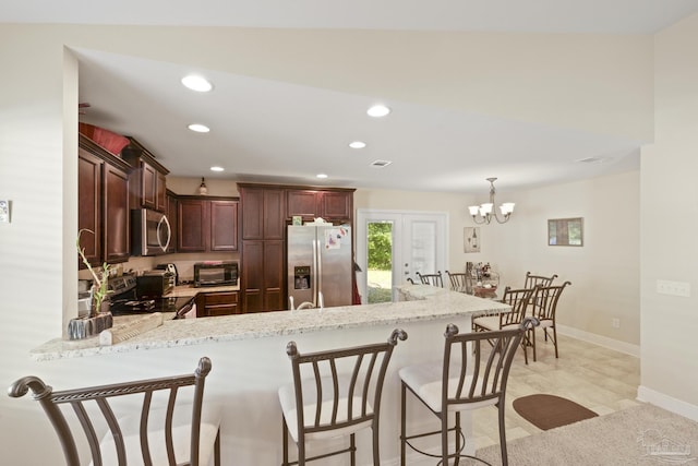 5183 Teresa Dr, Milton, FL 32583 - kitchen with appliances with stainless steel finishes, a peninsula, a breakfast bar, recessed lighting, and light stone countertops