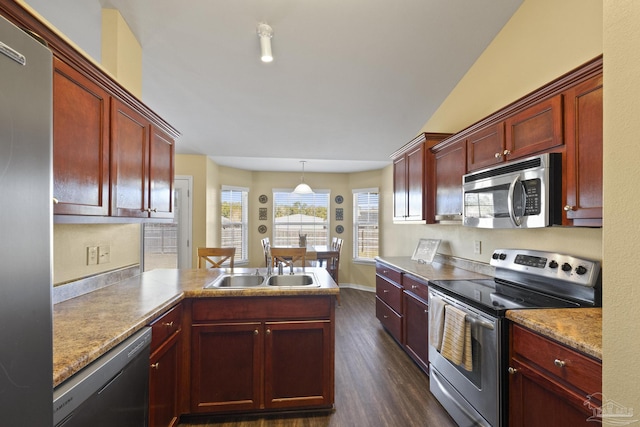 kitchen with dark wood-type flooring, sink, hanging light fixtures, and appliances with stainless steel finishes