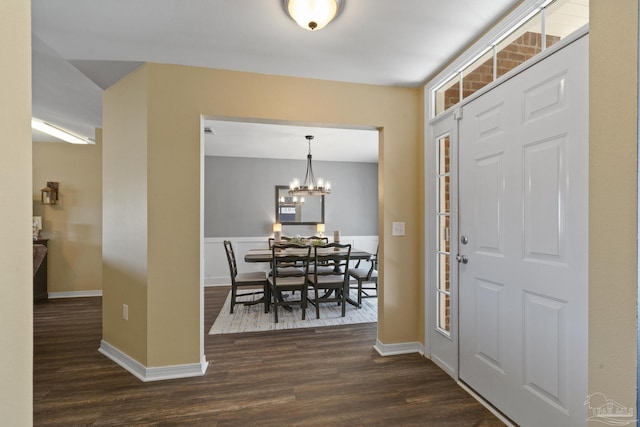 foyer entrance with a chandelier and dark hardwood / wood-style flooring