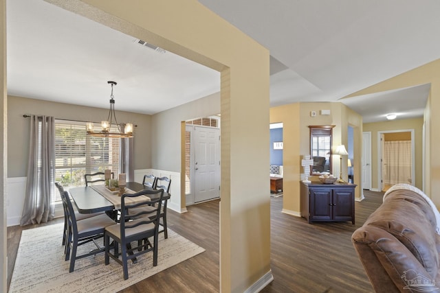 dining room featuring dark hardwood / wood-style flooring, a chandelier, and vaulted ceiling