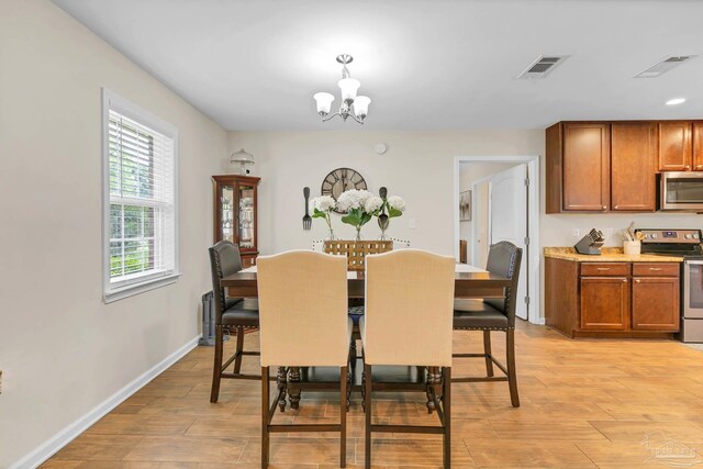 106 W Meadow Dr, Atmore, AL 36502 - dining space featuring a chandelier, light wood-type flooring, and baseboards