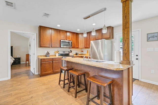106 W Meadow Dr, Atmore, AL 36502 - kitchen featuring stainless steel appliances, a kitchen breakfast bar, light wood-style floors, a sink, and recessed lighting