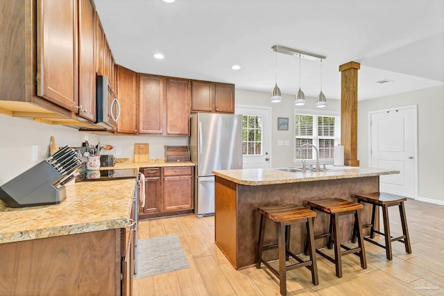 106 W Meadow Dr, Atmore, AL 36502 - kitchen featuring stainless steel appliances, a sink, a kitchen breakfast bar, light countertops, and light wood-style flooring