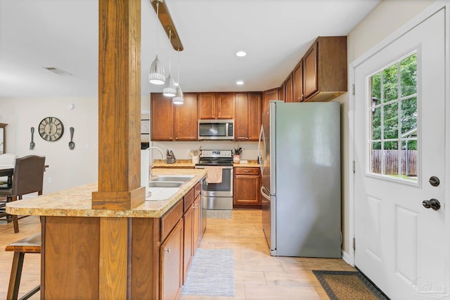 106 W Meadow Dr, Atmore, AL 36502 - kitchen featuring stainless steel appliances, a sink, light countertops, brown cabinets, and recessed lighting