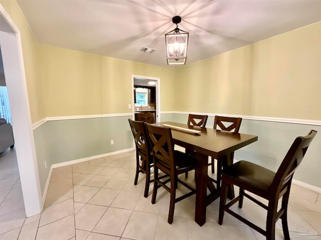 dining area featuring light tile patterned floors and an inviting chandelier