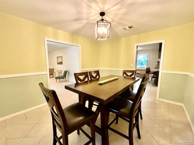 dining area with light tile patterned flooring and an inviting chandelier