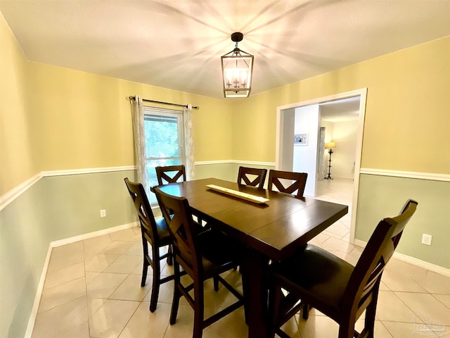 dining space featuring light tile patterned floors and a notable chandelier