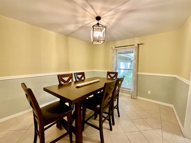 tiled dining room with a chandelier