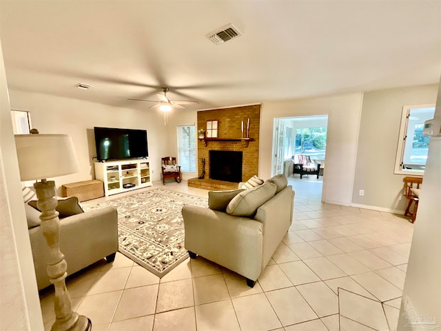 living room featuring light tile patterned floors, a brick fireplace, and ceiling fan