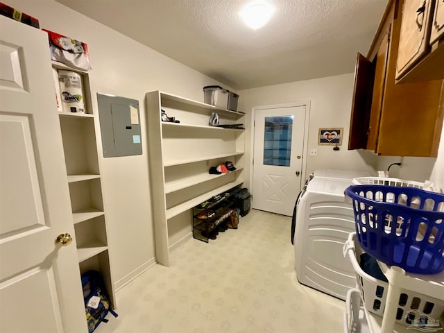 clothes washing area featuring cabinets, separate washer and dryer, a textured ceiling, and electric panel