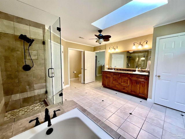 full bathroom featuring a skylight, ceiling fan, tile patterned flooring, and toilet